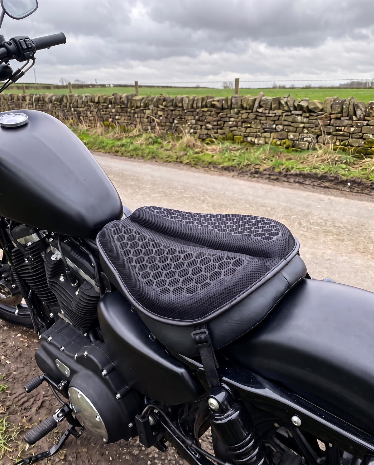 Gel seat pad strapped to the rider seat of a black cruiser