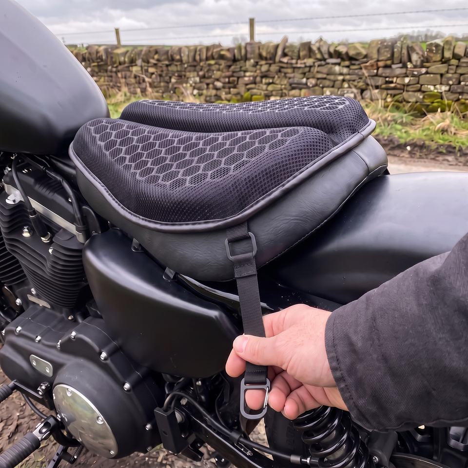 Elastic strap hooked to a loop on the gel seat pad's edge, pulled snug down the side of a cruiser seat