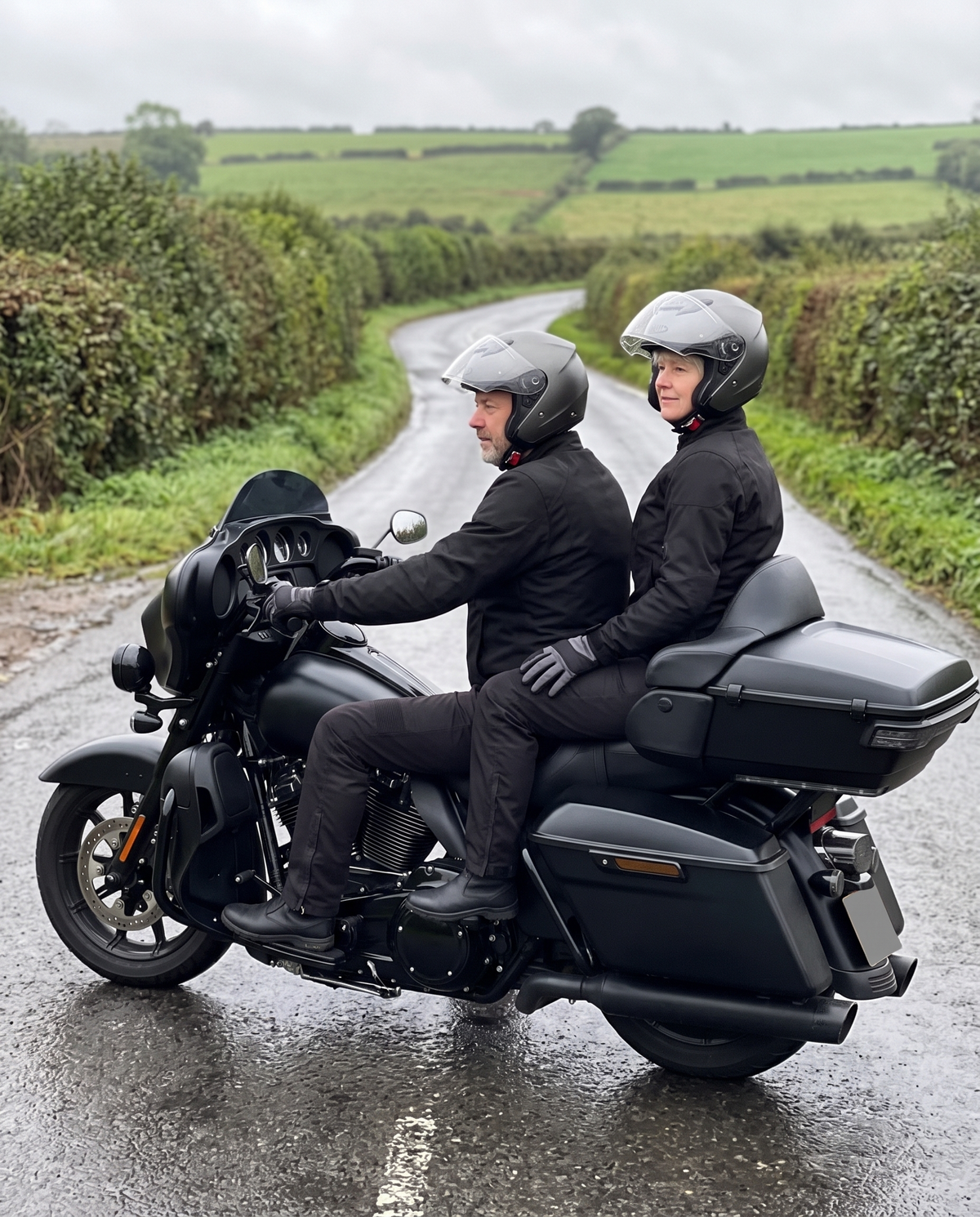 Couple riding two-up on a touring motorcycle on a UK country lane